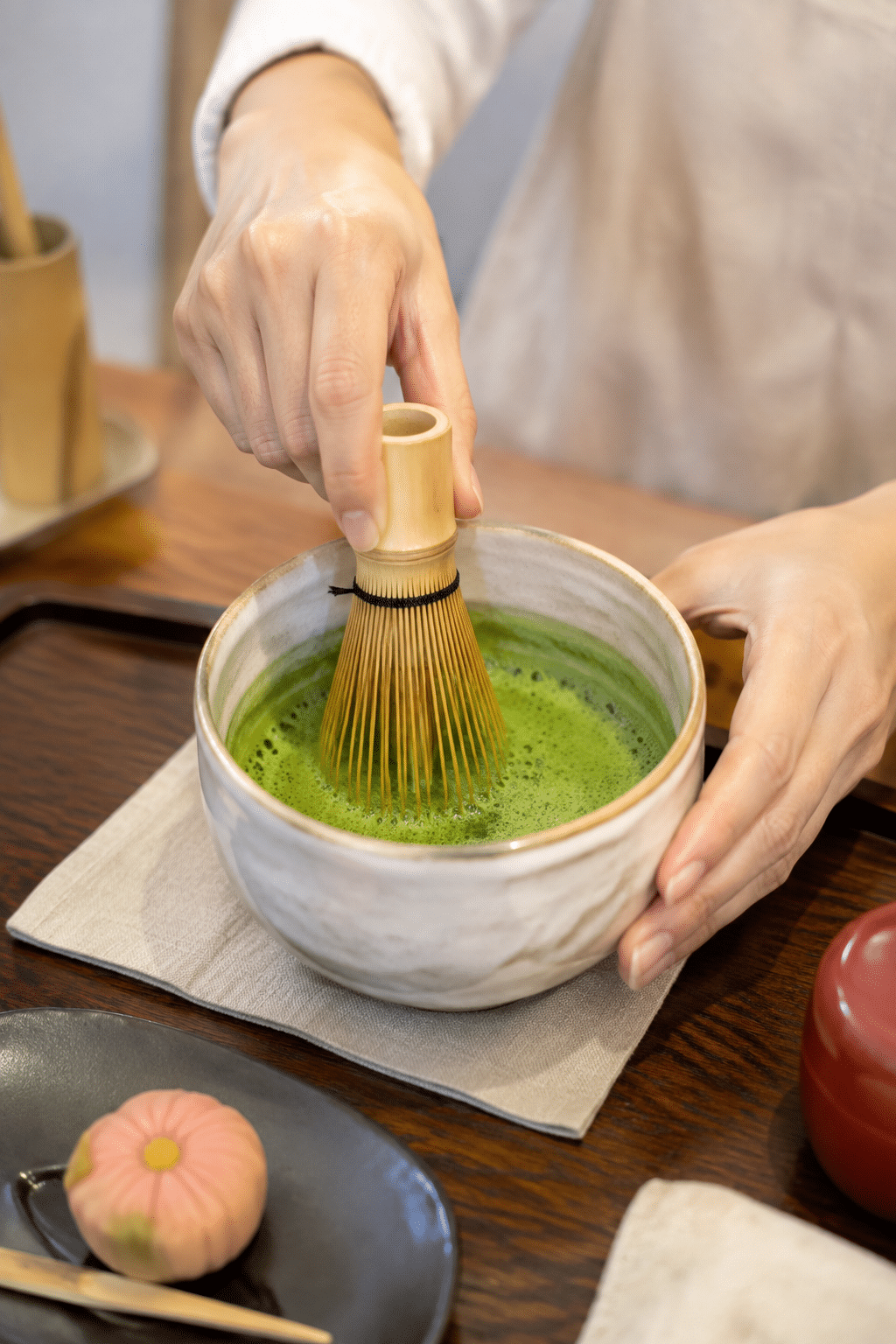 Hands whisking vivid green matcha during a Japanese tea ceremony workshop